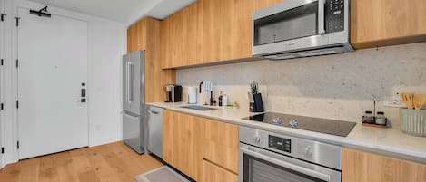 Une cuisine moderne dotée d’appareils électroménagers en acier inoxydable, d’armoires en bois et d’un plan de travail en granit.