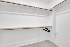 A closet with wooden rods and a black hanger.