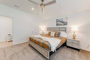 A bedroom with a bed, bedside tables, a ceiling fan, and a painting on the wall. - Brand New 4B Home in Jarrell (Jarrell)