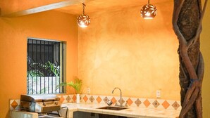 Una cocina funcional con lavamanos, estufa y lámparas colgantes.