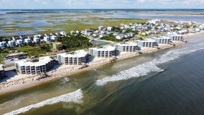 A coastal resort with beachfront villas, a sandy beach, and a view of the ocean.