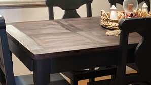 A dining table with chairs, a vase, and a woven basket.