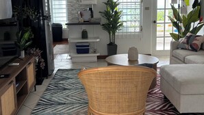 A spacious living area with a ceiling fan, a black refrigerator, a dining table, and a sofa. - Paradise View - Stunning views near Dickenson Bay Beach in Antigua & Barbuda (Dickenson Bay Beach)