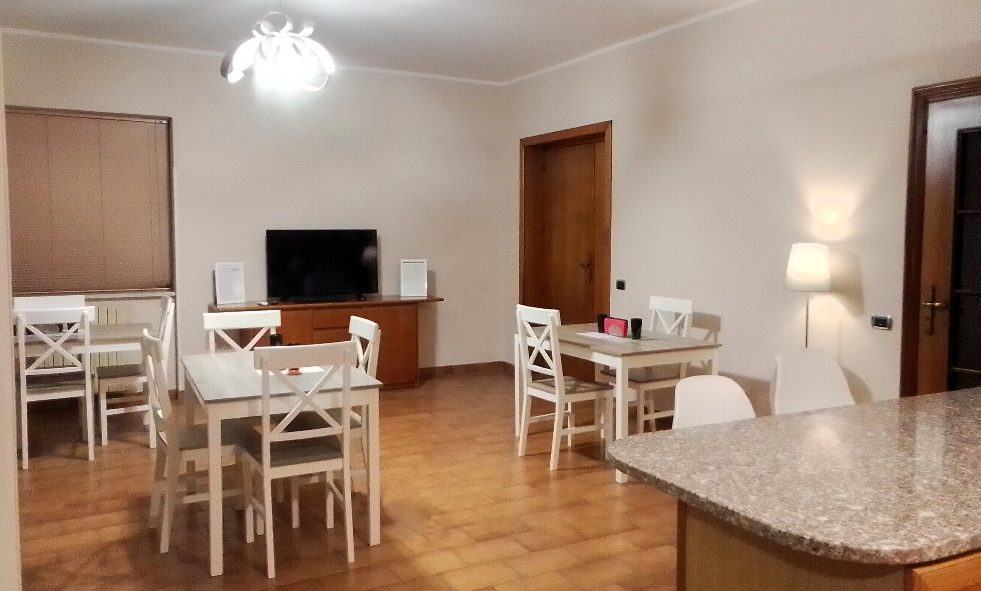 Un espacio habitable compacto con comedor, televisor y encimera de cocina.