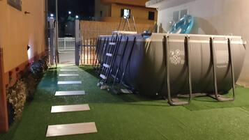 Ein Poolbereich im Freien mit einer Leiter und einem überdachten Pool.