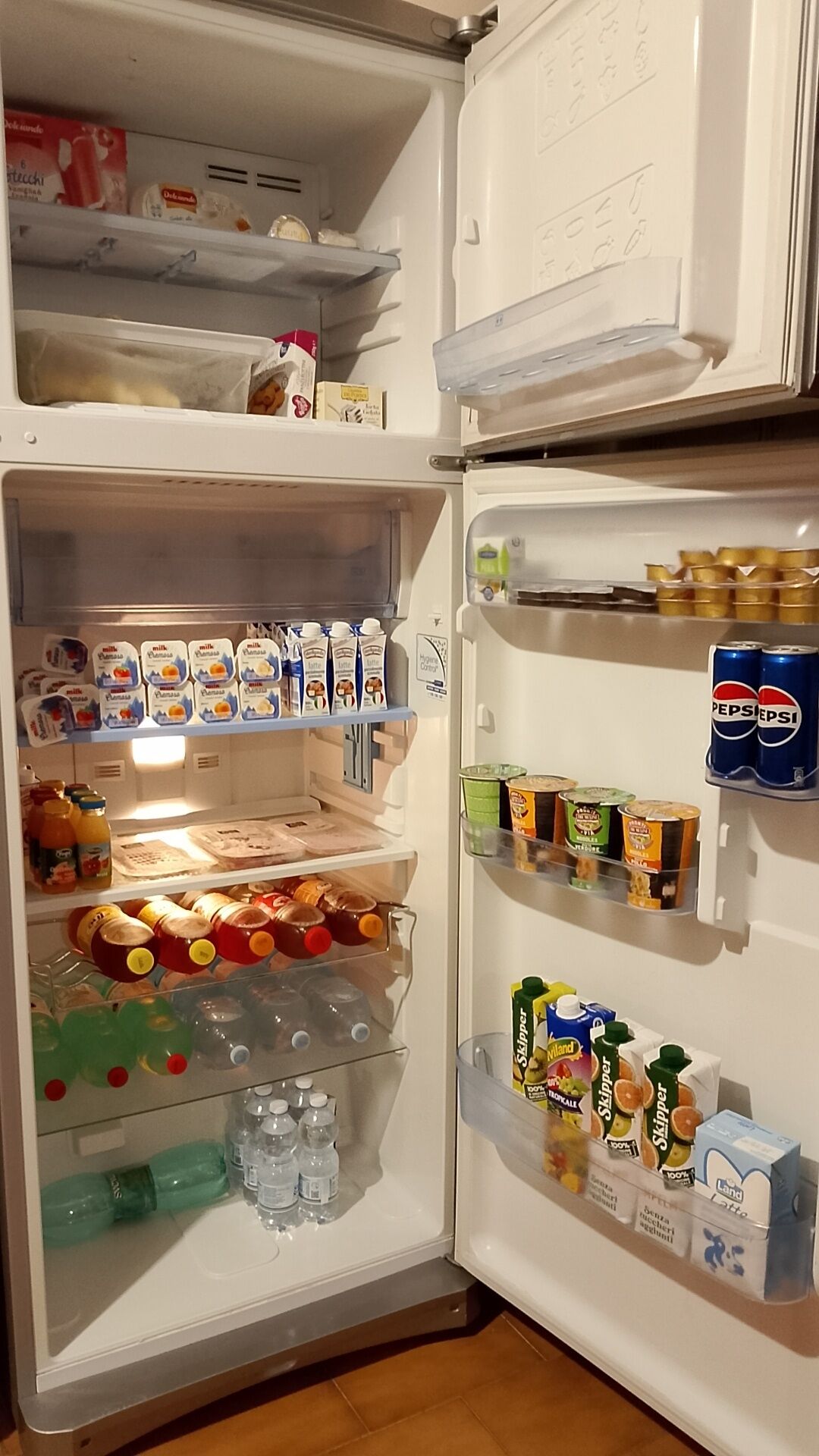 A refrigerator stocked with various food items and beverages.