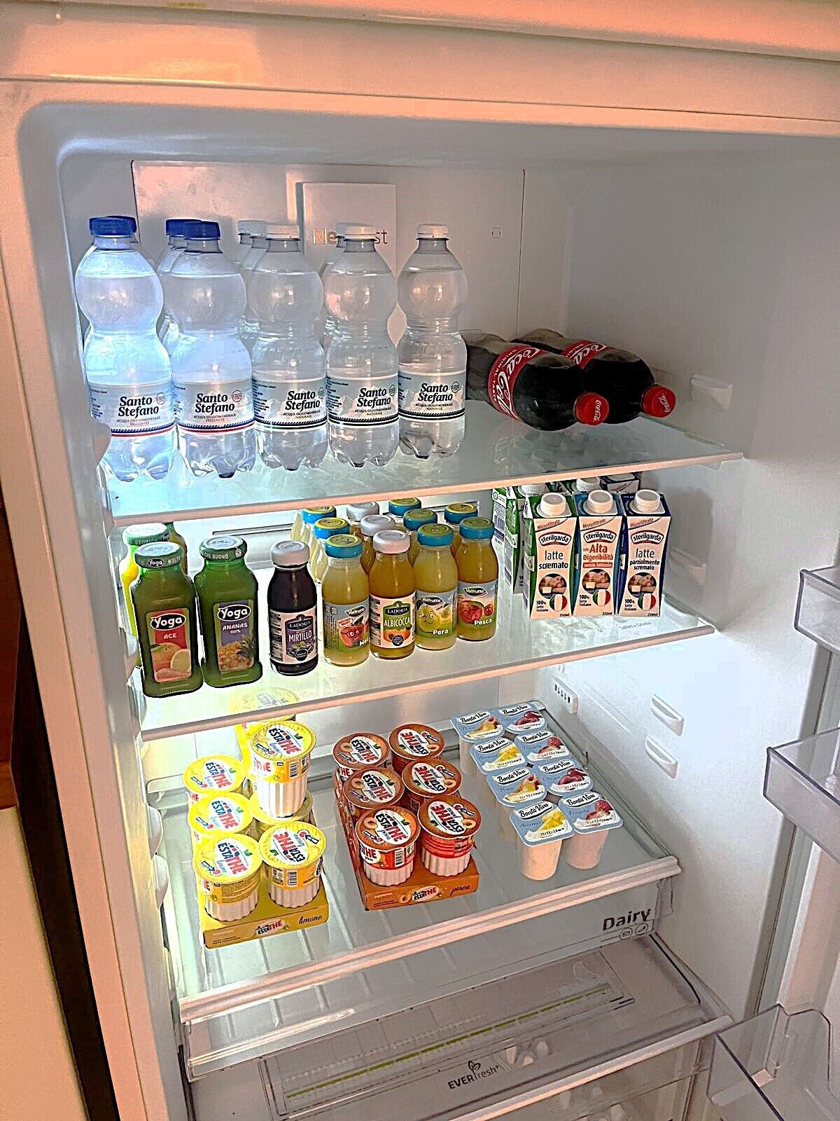 A refrigerator stocked with various beverages and dairy products.