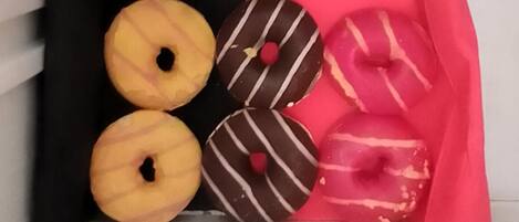 Eine Schublade mit vier Donuts, davon zwei schlicht und zwei mit Schokoladenglasur.