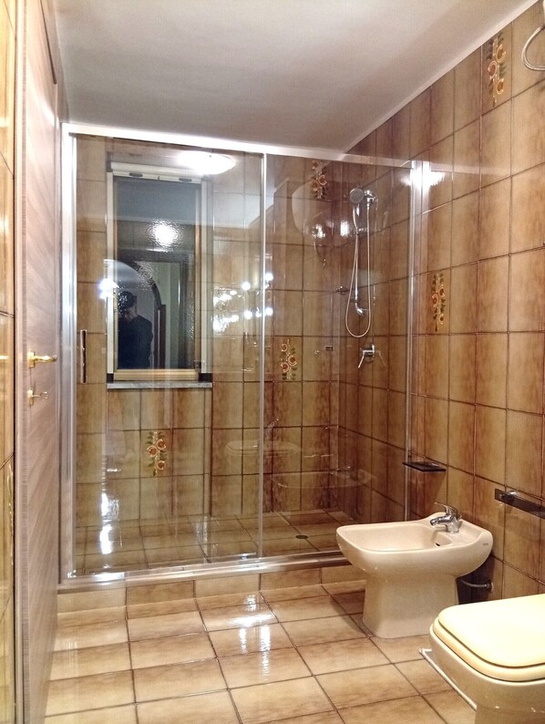 A modern bathroom with a glass-enclosed shower, a bidet, and a toilet. - House Revolution Style FC (Oliveto Citra)