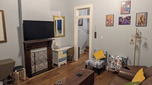 Sala de estar com lareira, sofá, mesa de centro e televisão.
