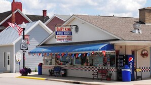 A motel named 'DAIRY KING' with a sign indicating 'MOTEL ROOMS' and 'CONES-SUNDAS-MALTS'.