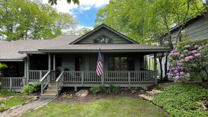 A two-story house with a porch, a flag, and a garden. - Mountain retreat! With spectacular views! (Burnsville)