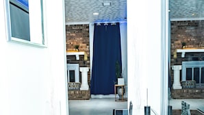 Ein modernes Interieur mit Marmorboden, einer Glastrennwand und einer Backsteinwand.