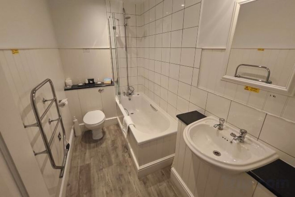 A compact bathroom with a toilet, bathtub, and sink.
