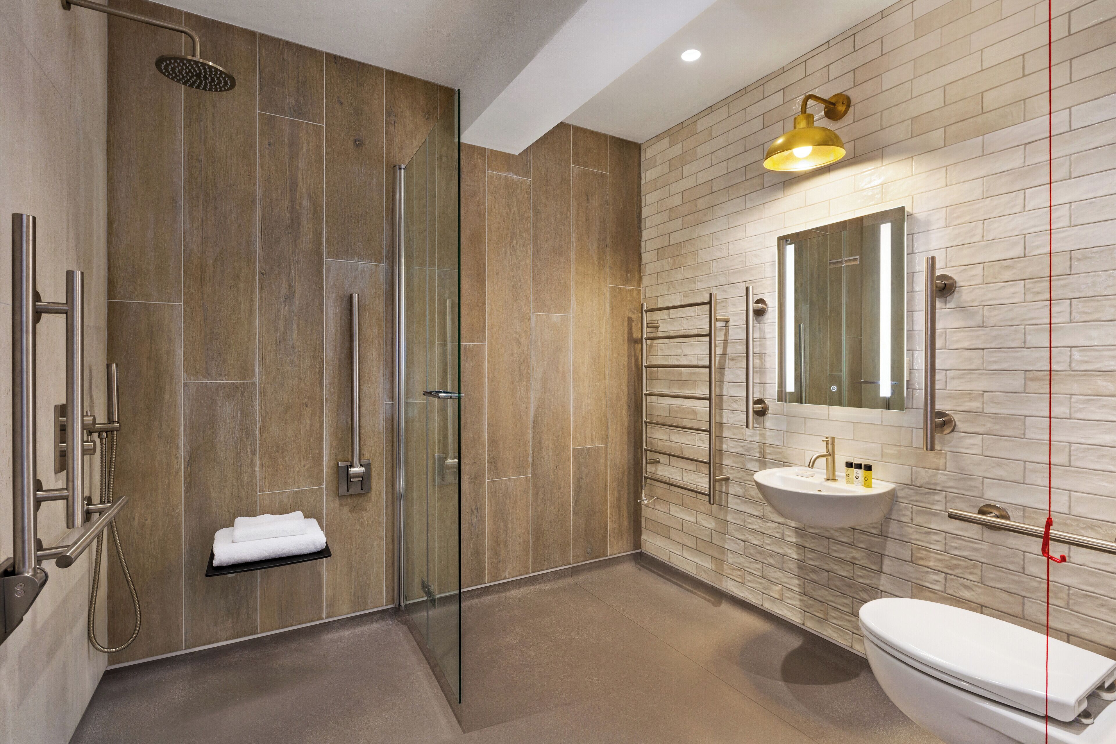 A modern bathroom with a glass-enclosed shower, a white sink, and a large mirror.