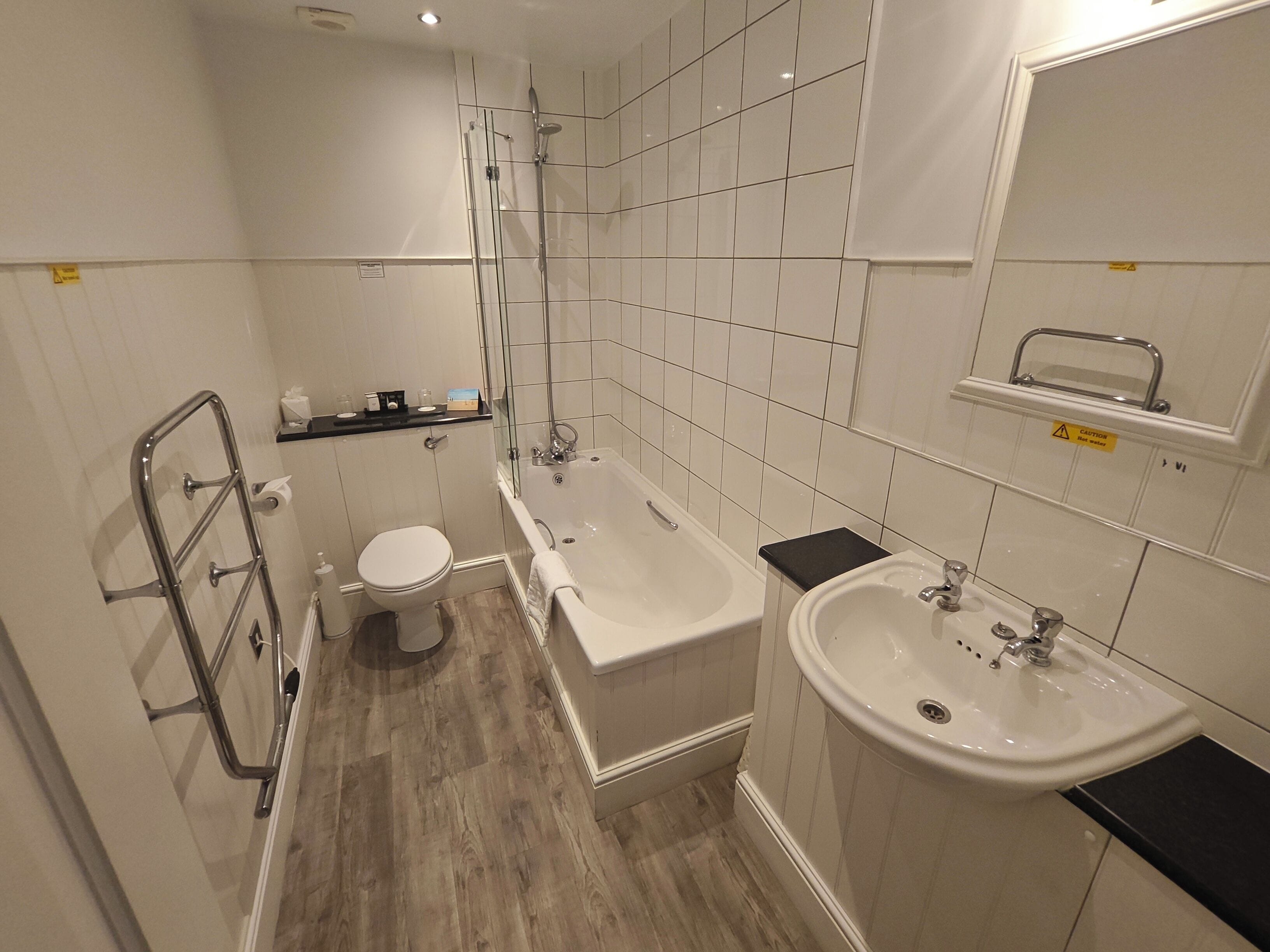 A modern bathroom with a toilet, bathtub, and sink.