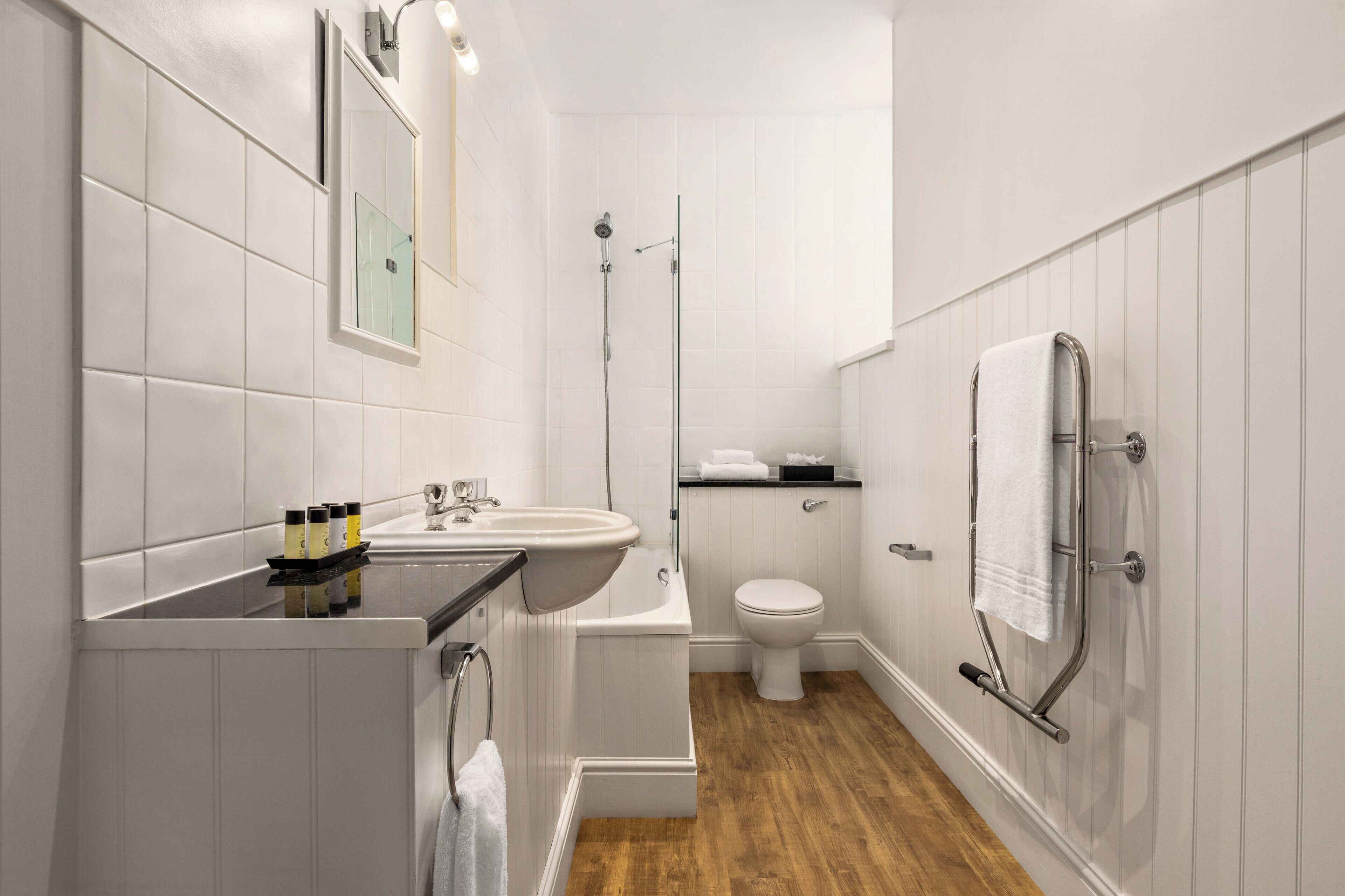 A modern bathroom with a sink, toilet, and shower.