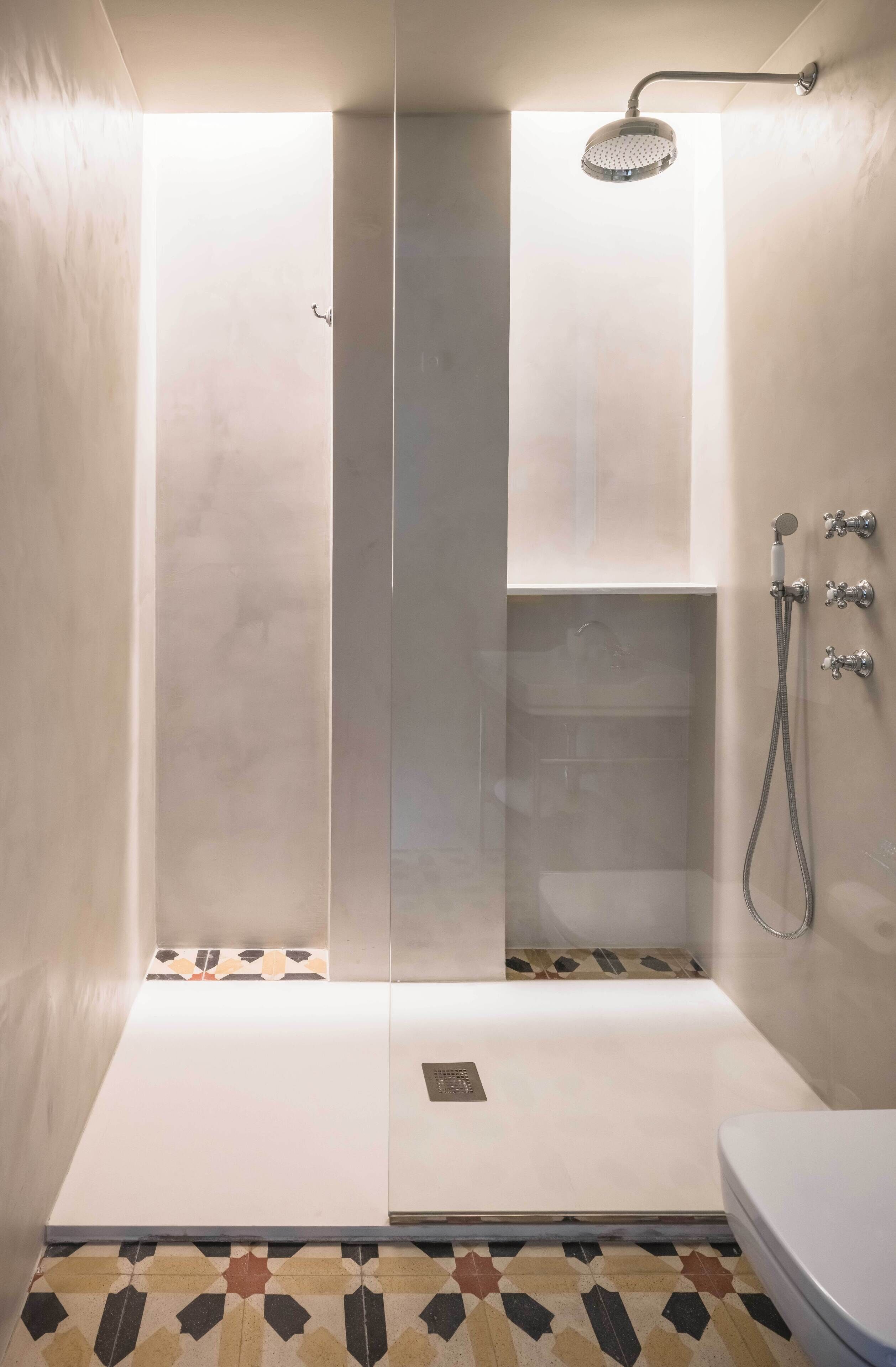 A modern bathroom with a glass-enclosed shower, a toilet, and a sink.