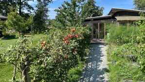 A garden path leading to a building with a wooden exterior and a glass door. - Stunning home in Löttorp with WiFi (Löttorp)