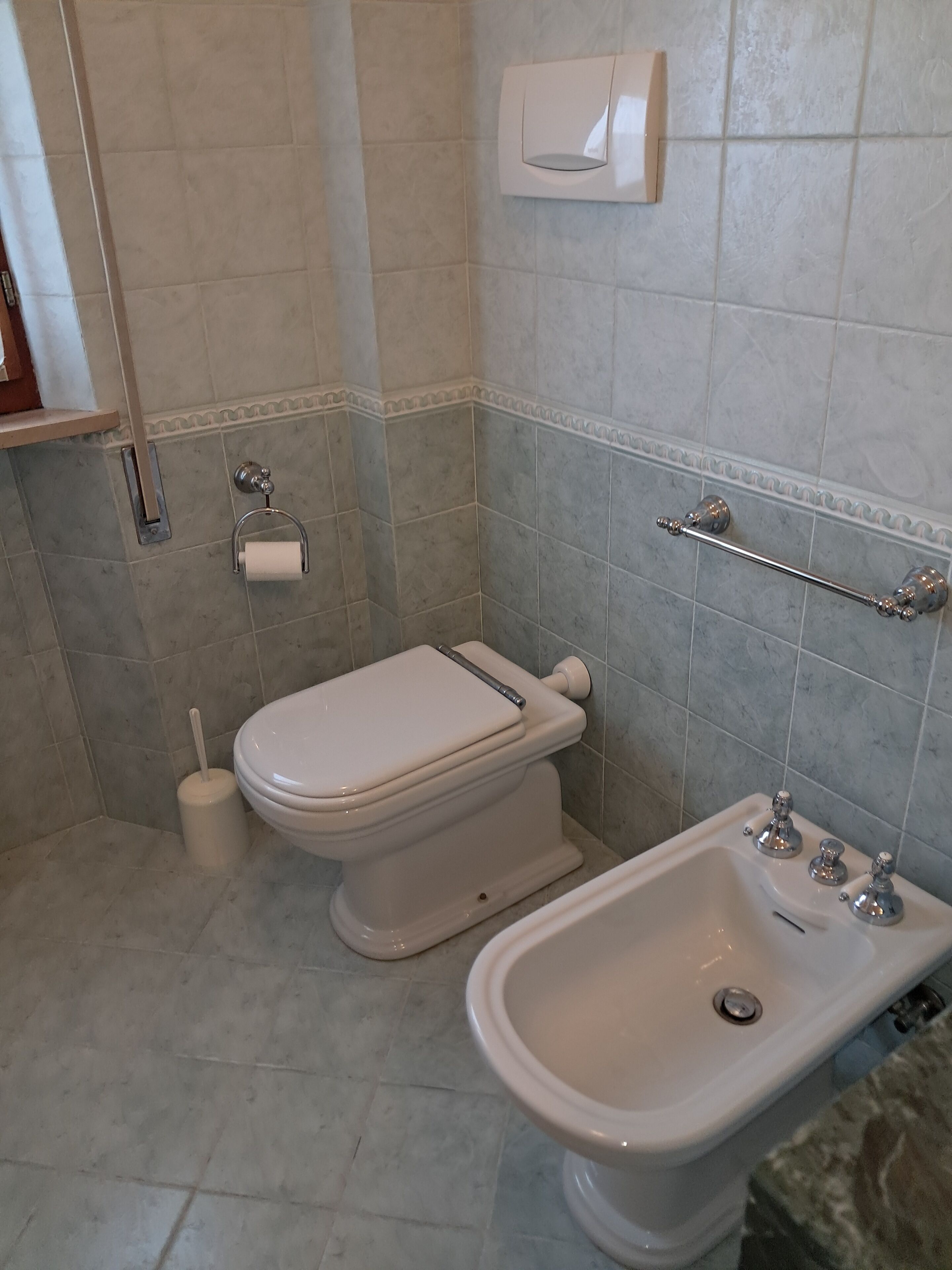 Un baño con inodoro, bidé y lavabo.