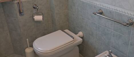 Un baño con inodoro, bidé y lavabo.