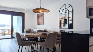 Un espace repas moderne avec une table ronde, des chaises et un luminaire suspendu.