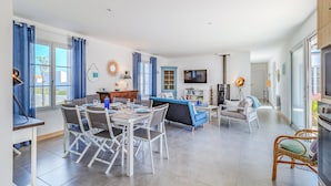 Una sala de estar moderna con comedor, sofá, televisión y chimenea.