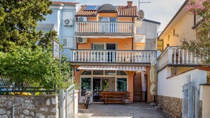 Un bâtiment à deux étages doté d’un balcon, d’une porte et d’une moto garée.