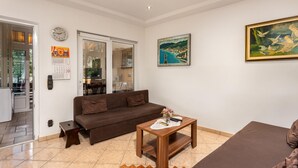 Un salon avec un canapé, une table basse et un tableau accroché au mur.
