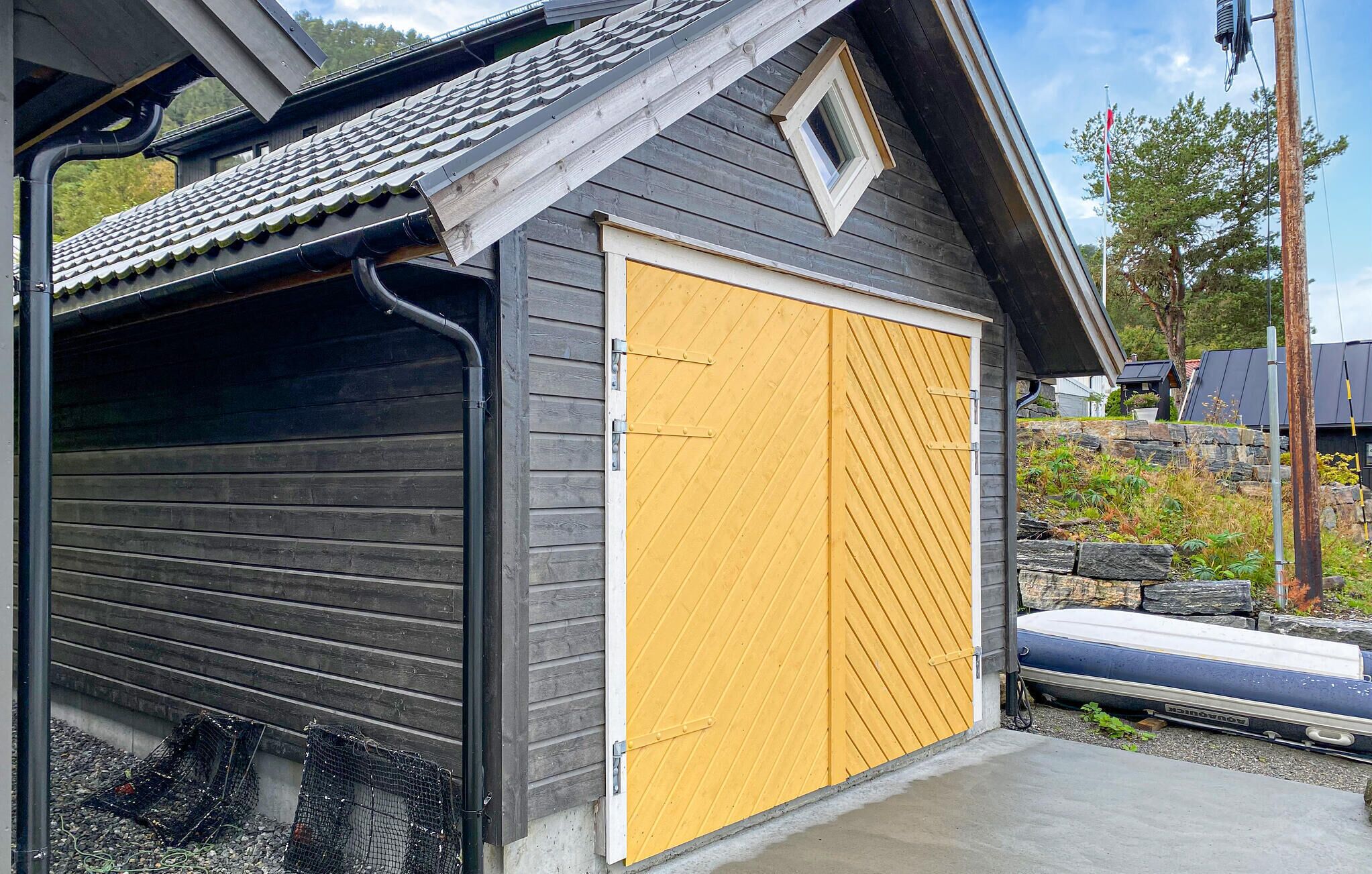 A garage with a yellow door, a black roof, and a small window.