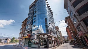 A hotel with a modern glass facade, a visible entrance, and a sign indicating it is a hotel. - Hotel Platinium Palace (Cusco)