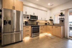 Una cocina moderna con electrodomésticos de acero inoxidable, gabinetes de madera y un horno empotrado.