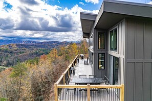 A modern building with a deck overlooking a mountainous landscape. - Gorgeous Lux Pool cabin Incredible Views (Sevierville)