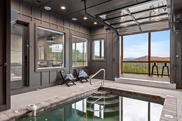 A spa area with a pool, large windows, and a view of the mountains. - Gorgeous Lux Pool cabin Incredible Views (Sevierville)