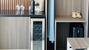 A modern kitchenette with a built-in oven, a wine cooler, and a small refrigerator. - Hacienda Montero (Valle de Guadalupe)