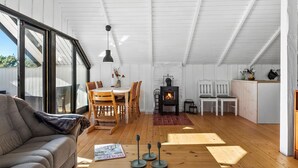 A cozy loft with a dining area, a sofa, a fireplace, and a kitchen.