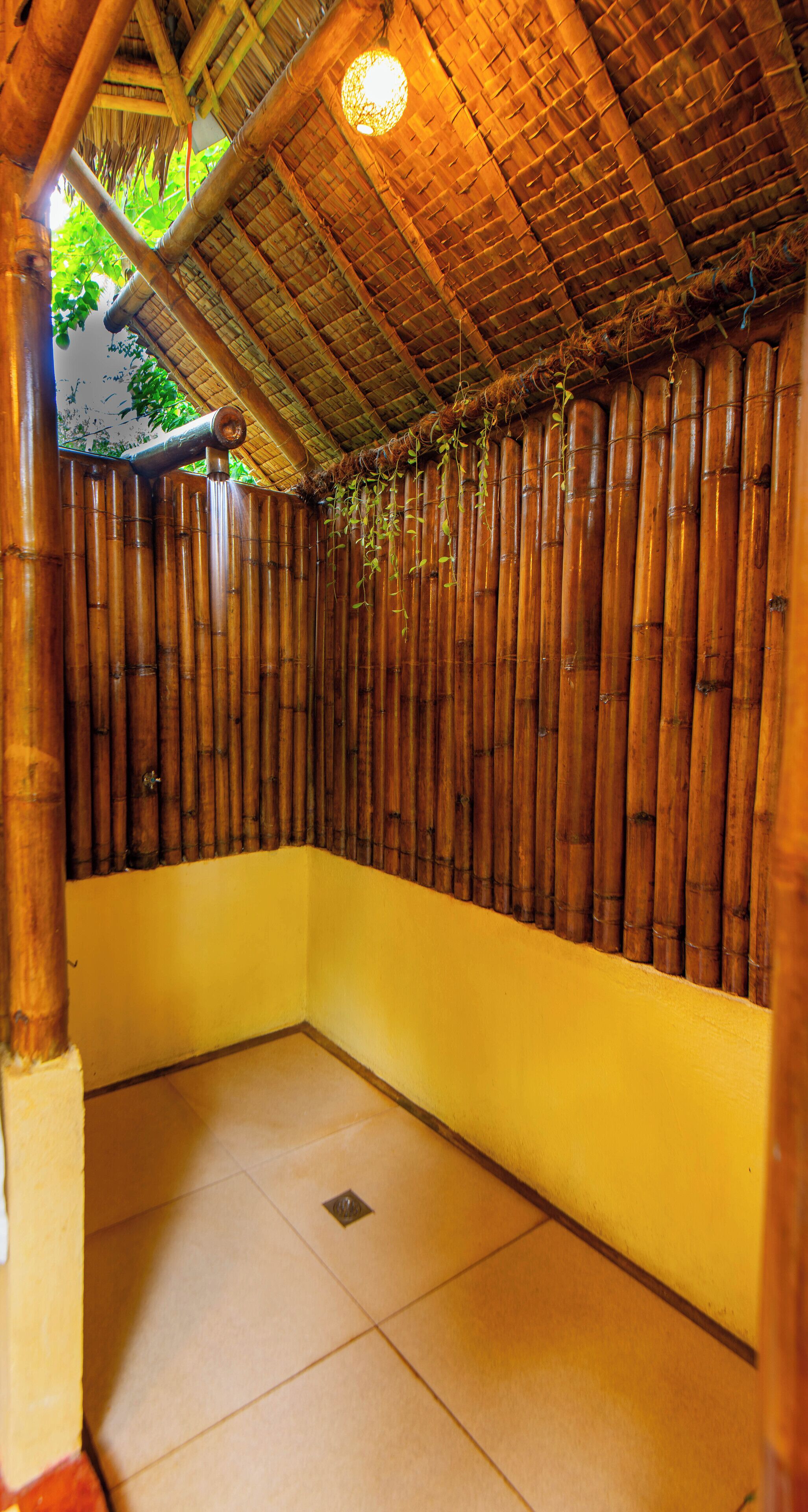 Una habitación con pared de bambú, suelo amarillo y techo de paja.