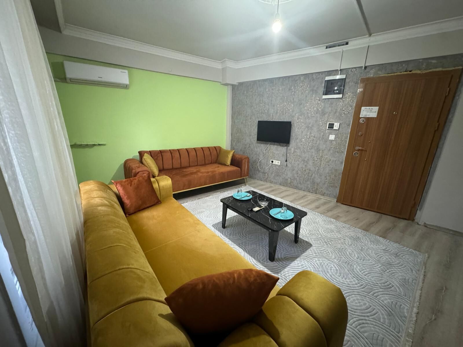 A living room with a sofa set, a coffee table, a TV, and a wardrobe.