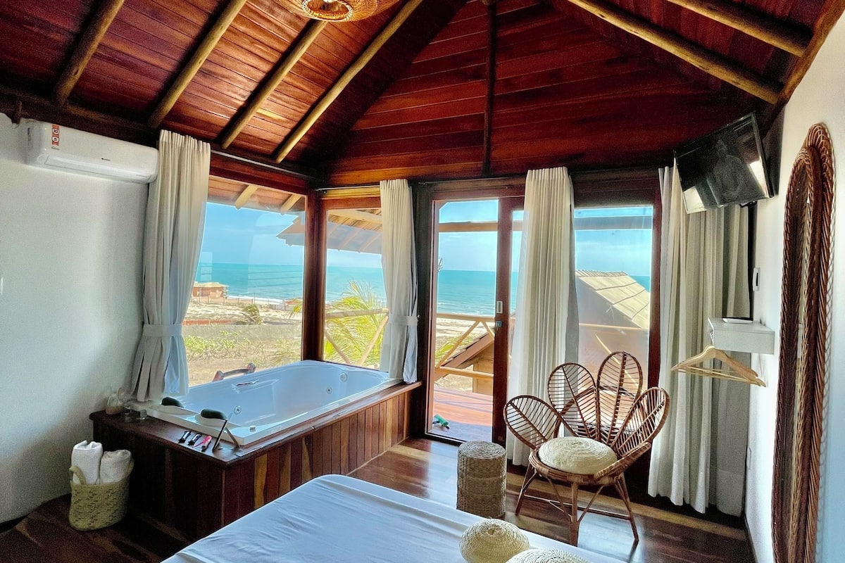 Una habitación con una cama grande, un escritorio y vista a la playa.