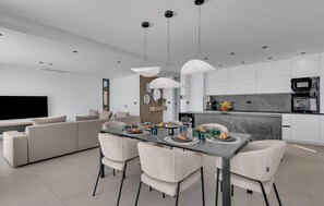Une cuisine moderne avec un coin repas, un canapé et un téléviseur.