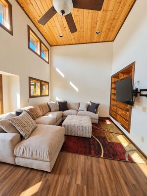 Bright vaulted living room with oversized sectional and warm wood ceilings - Mercer House on Major Snowmobile and ATV Trail (Mercer)