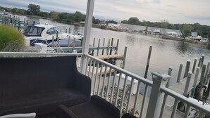 A balcony with a view of a marina, docked boats, and a pier.