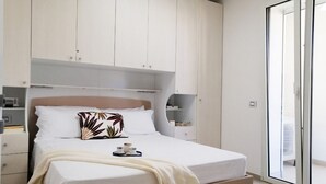 A modern bedroom with a bed, a bedside table, a nightstand, and a wardrobe. - Holihome_La Gioia Tortoreto (Tortoreto Lido)