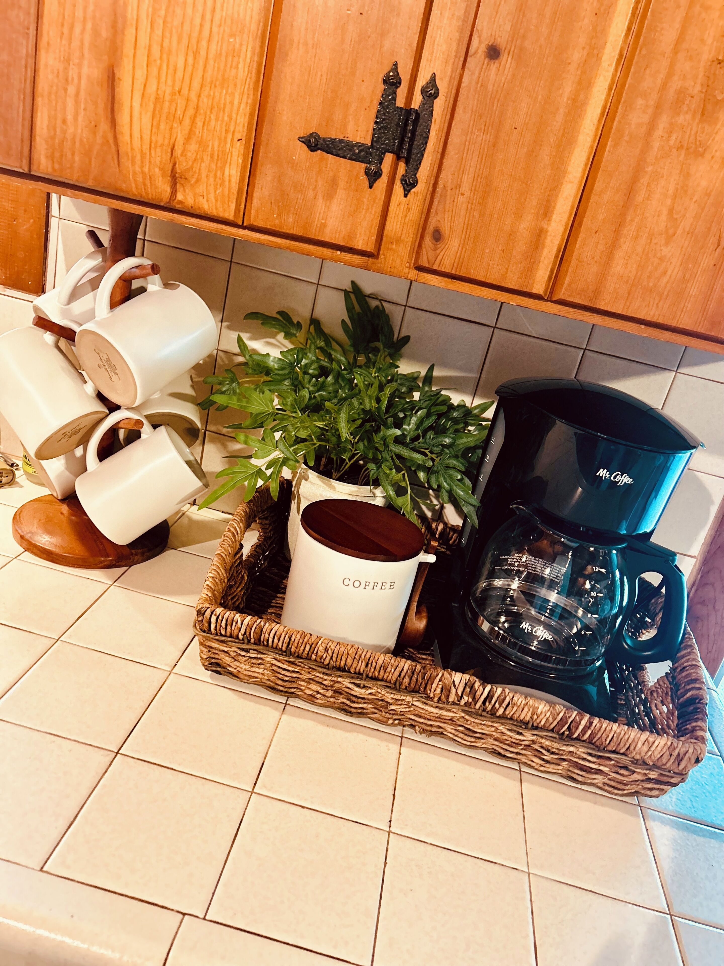 Een keukentrap met een koffiehoek, inclusief een koffiezetapparaat, een koffiemok en een plant.