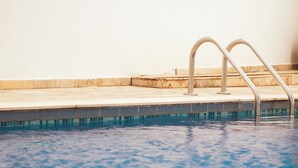 A swimming pool with metal handrails and a tiled edge. - Charming 1-bedroom apartment in wonderful Barranquilla with AC, WiFi (Barranquilla)
