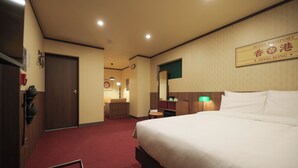 Ein Hotelzimmer mit einem großen Bett, einem Schreibtisch, einem Stuhl, einem Spiegel und einem Schild, das anzeigt, dass es sich um ein Passport Hotel in Hongkong handelt.