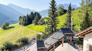 A mountain view with a pathway leading to a building with a sloped roof and wooden beams. - Toissa A4 by Interhome (Savognin)