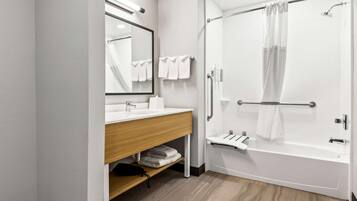 A modern bathroom with a white sink, mirror, and shower.