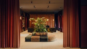 A lobby with a reception desk, a large potted plant, and a seating area with patterned cushions. - Flaner Hotel, WorldHotels Crafted (Warsaw)