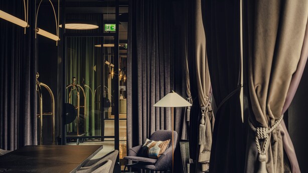 A modern conference room with a long table, multiple chairs, a sofa, and a lamp. - Flaner Hotel, WorldHotels Crafted (Warsaw)